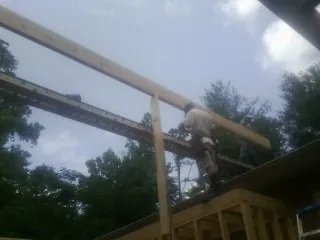 Carpenter setting a ridge beam over a new addition frame — Ice Dam Removal by Roofing Brothers in Tigrett