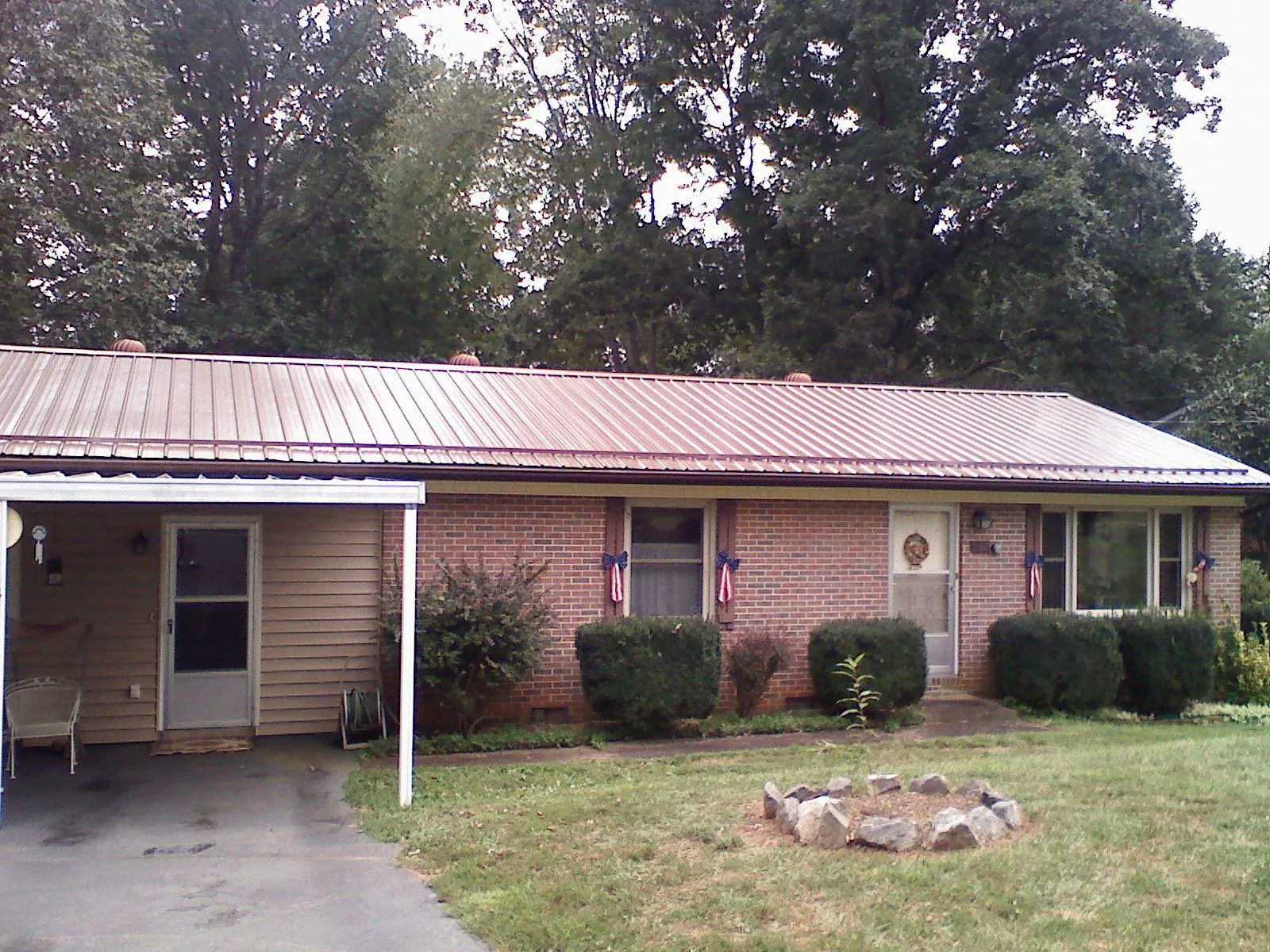 Bronze metal roof and carport on a brick ranch home — Roof Repair work by our crew in Tigrett